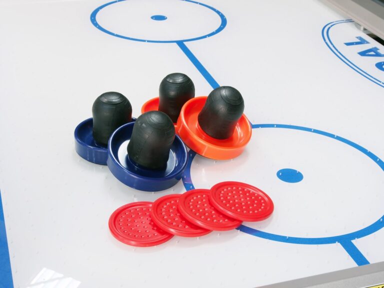 Close-up surface of an air hockey table from the air hockey tables range, showing a puck and pusher.